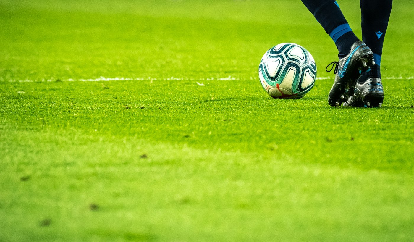 Footballeur en action sur une pelouse